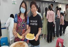 一群人在桌子前切蛋糕中度可信度描述已自动生成